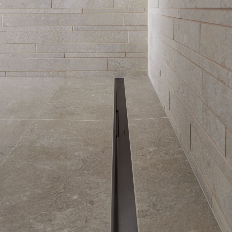 Vanduo nuteka per elegantišką nerūdijančio plieno profilį. Vanduo nuteka per elegantišką nerūdijančio plieno profilį.