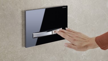Juodos spalvos Sigma50 vandens nuleidimo mygtukas, ranka įjungiamas plovimas (© Geberit)