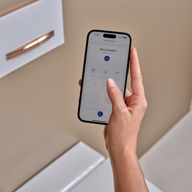 Moteris išmaniajame telefone naudoja Geberit Home programėlę Moteris išmaniajame telefone naudoja Geberit Home programėlę