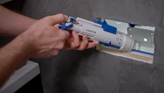 Vyras montuoja Geberit nuplovimo vandens vožtuvą į potinkinį bakelį (© Ben Huggler) Vyras montuoja Geberit nuplovimo vandens vožtuvą į potinkinį bakelį (© Ben Huggler)