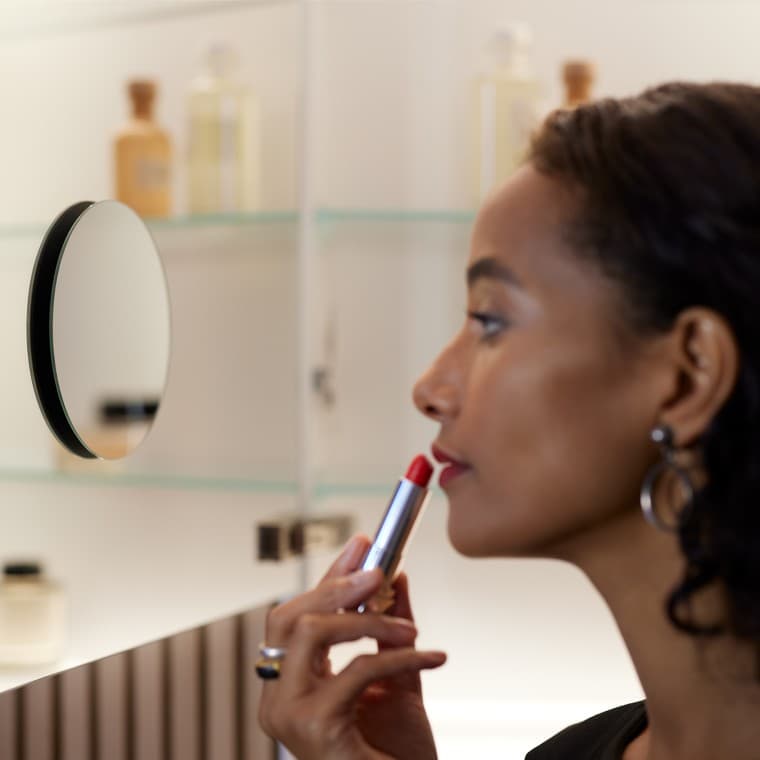 Moteris darosi makiažą priešais veidrodį Moteris darosi makiažą priešais veidrodį